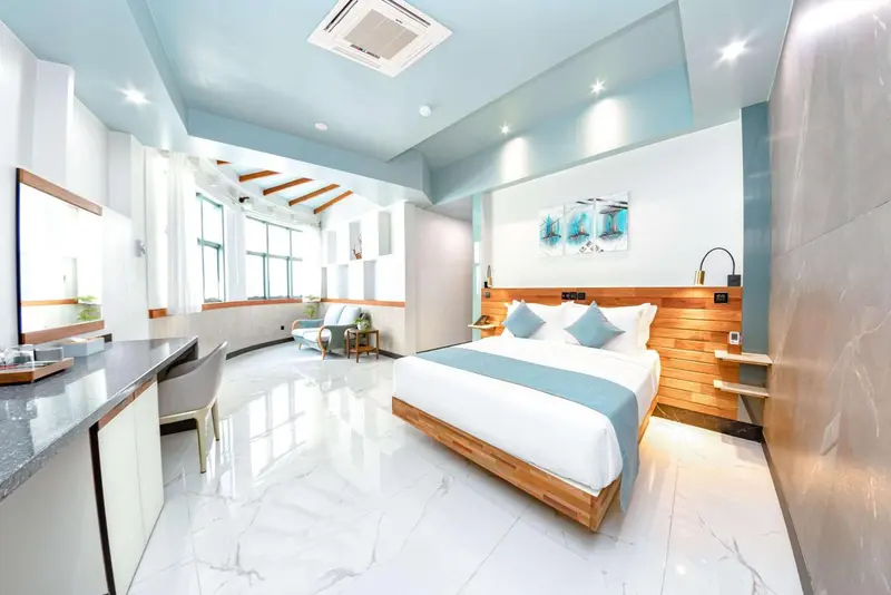 Une chambre lumineuse avec un lit double et un espace détente.