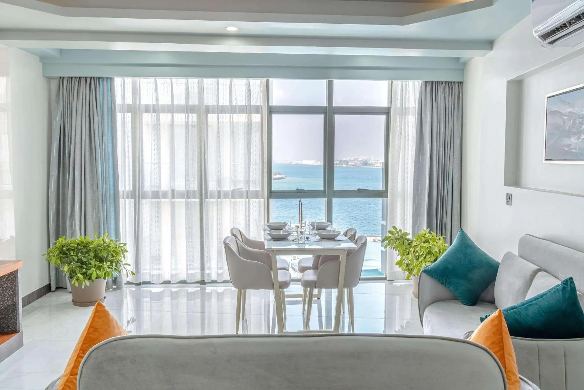 Espace de vie lumineux avec coin repas et vue sur la mer.