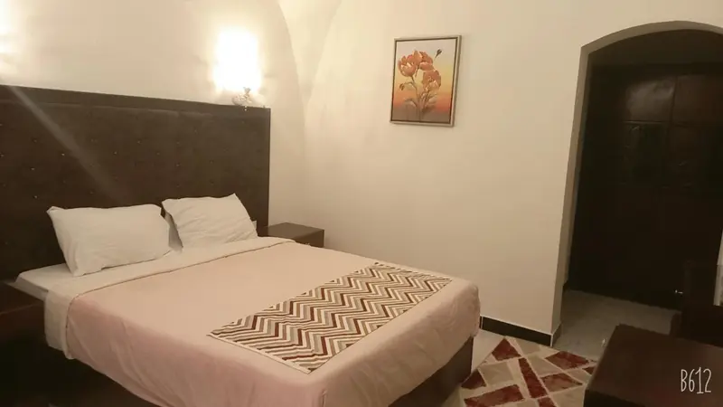 Une chambre lumineuse avec un lit double et une décoration sobre.