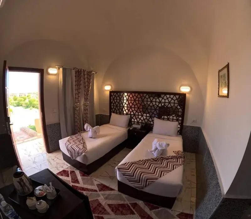 Chambre avec deux lits simples et une décoration murale.