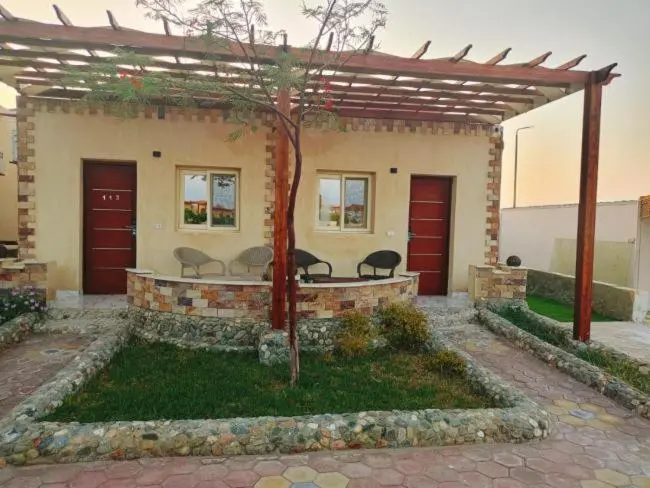 Façade d'un bâtiment avec des ouvertures et un aménagement paysager.