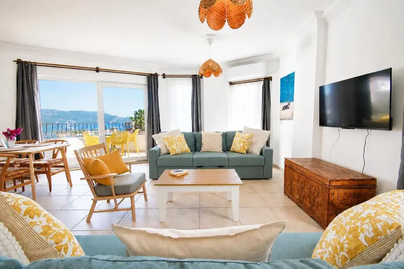 Un salon lumineux s'ouvre sur une terrasse avec vue sur la mer.