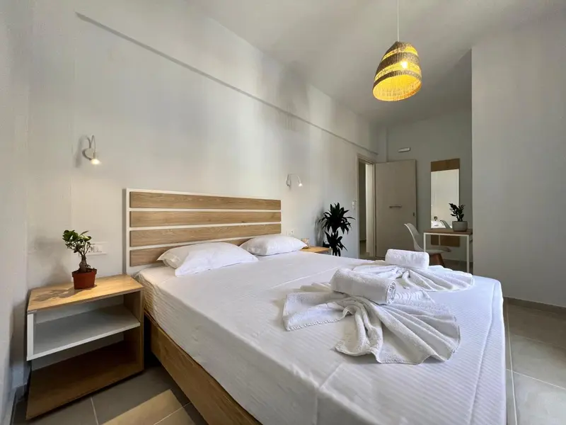 Une chambre lumineuse avec un grand lit et des tables de chevet.