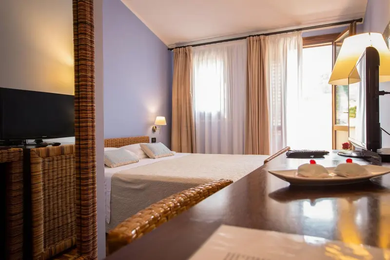 Une chambre lumineuse avec un lit double et une table de chevet.