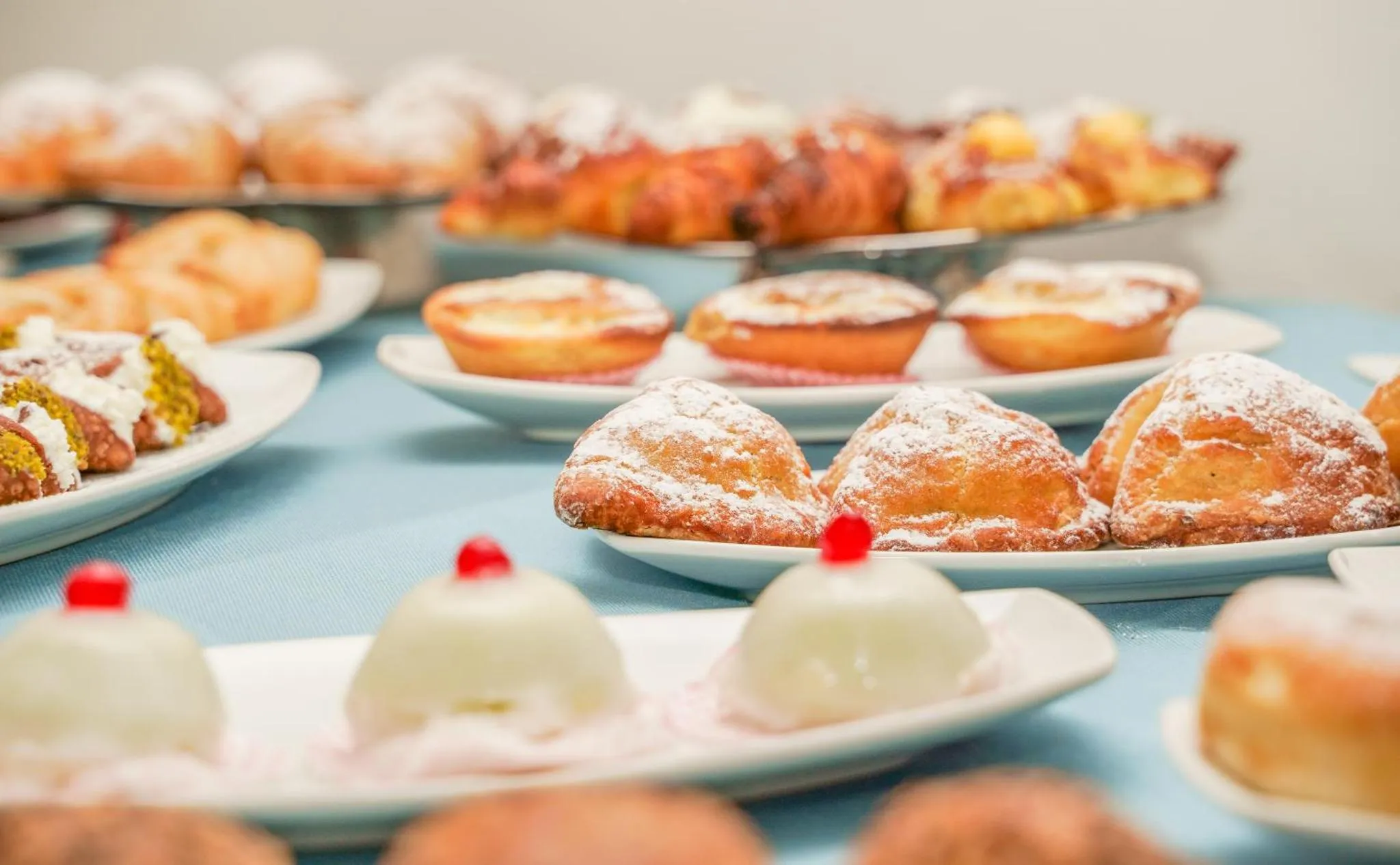 Assortiment de pâtisseries et de viennoiseries présentées sur des plateaux.