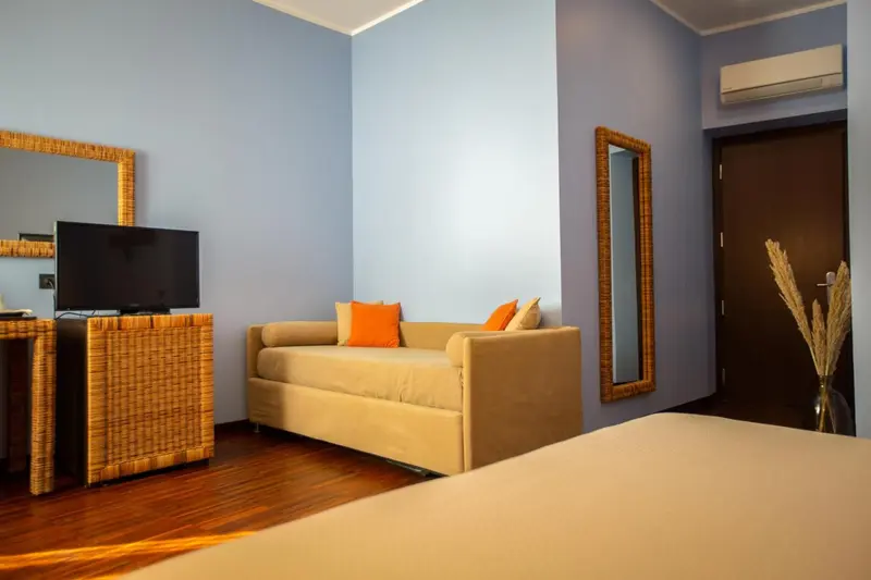 Espace de détente avec canapé beige et télévision à écran plat.