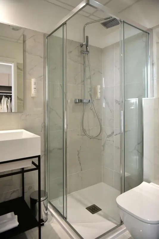 Une douche à l'italienne moderne dans une salle de bain carrelée.