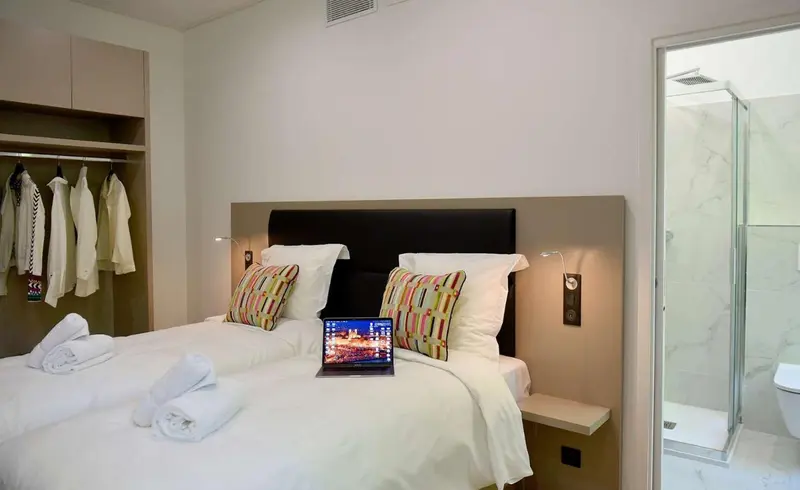 Une chambre lumineuse avec un grand lit et une salle de bain attenante.