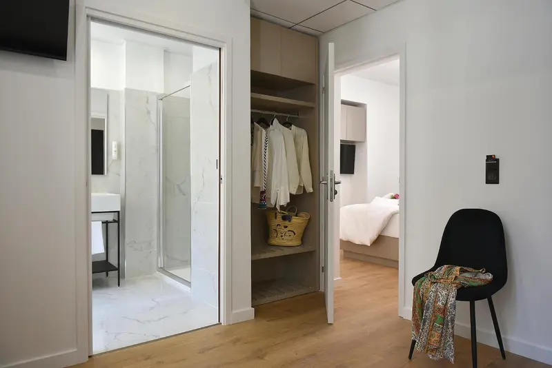 Intérieur clair avec une salle de bain carrelée et une chambre à coucher.