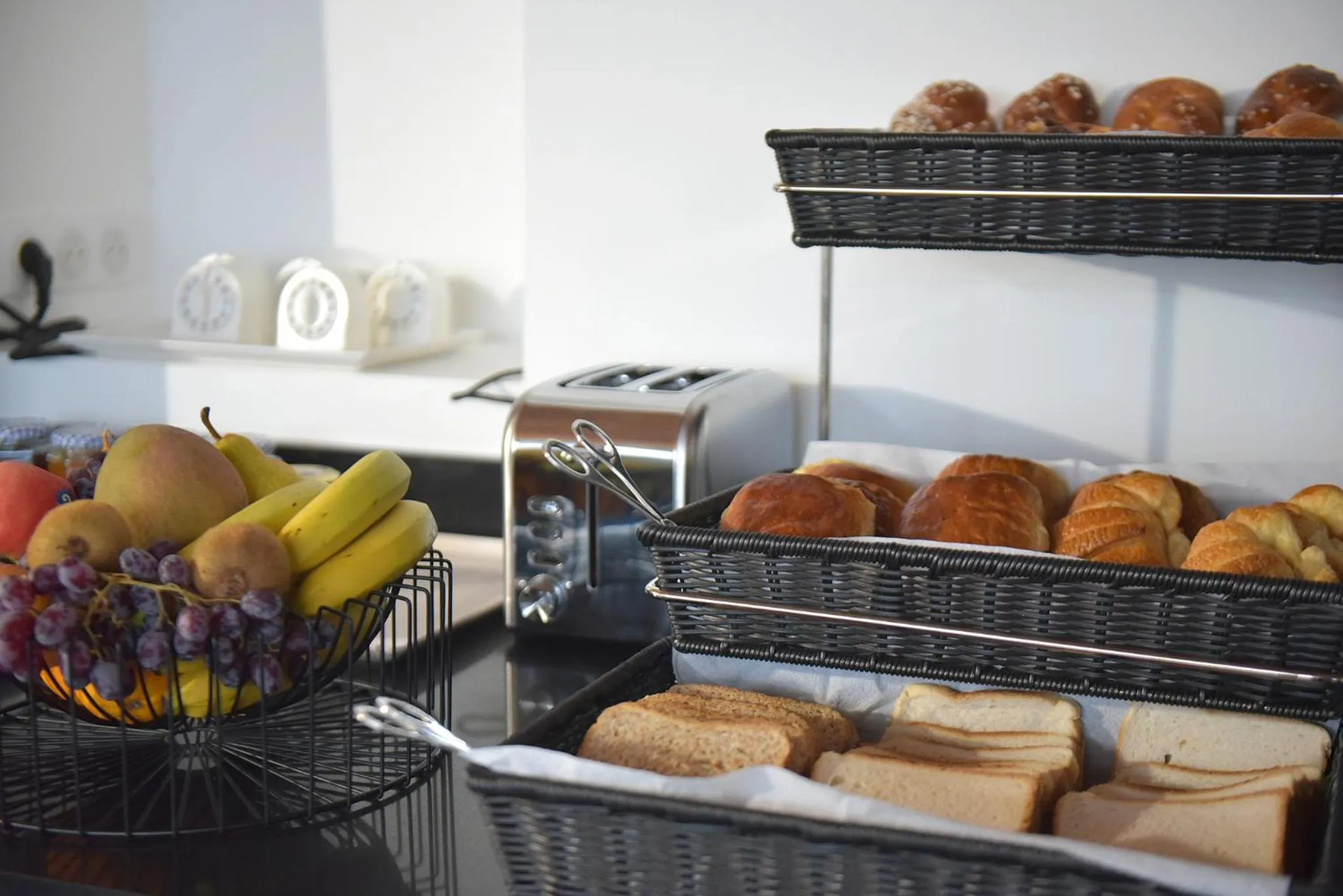 Une table propose des viennoiseries, des fruits et du pain.
