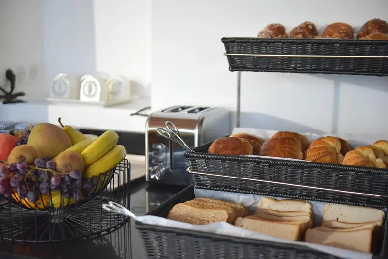Une table propose des viennoiseries, des fruits et du pain.