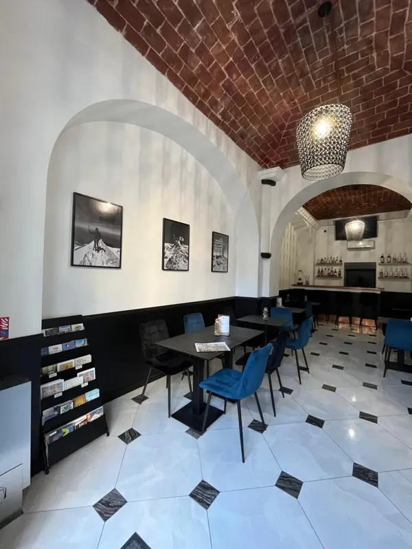 Une salle à manger avec des tables et des chaises bleues sous des arches décoratives.