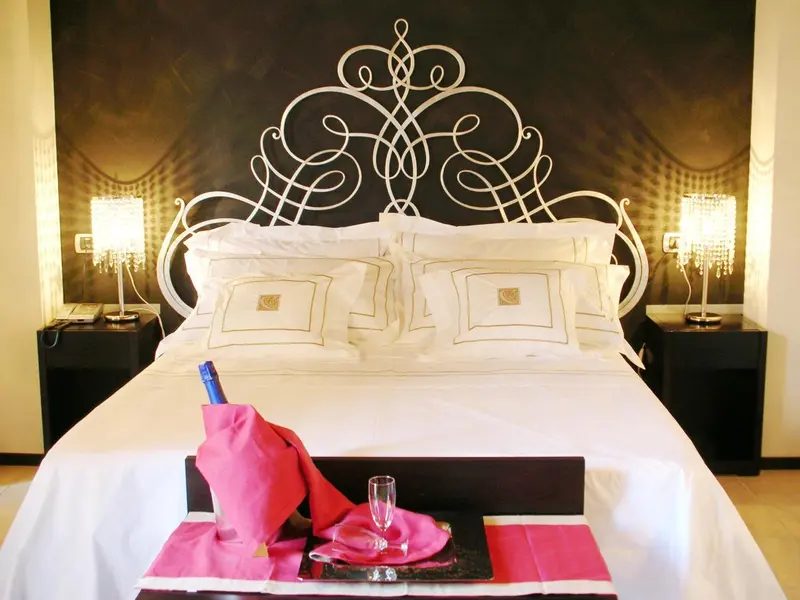 Un lit recouvert d'une courtepointe blanche et de coussins decoratifs dans une chambre.