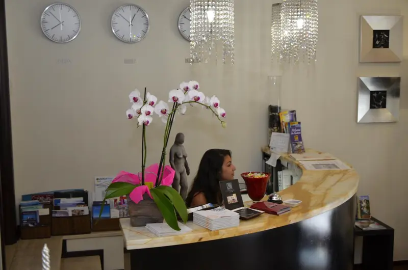 Un comptoir d'accueil avec une personne et des éléments de décoration florale.