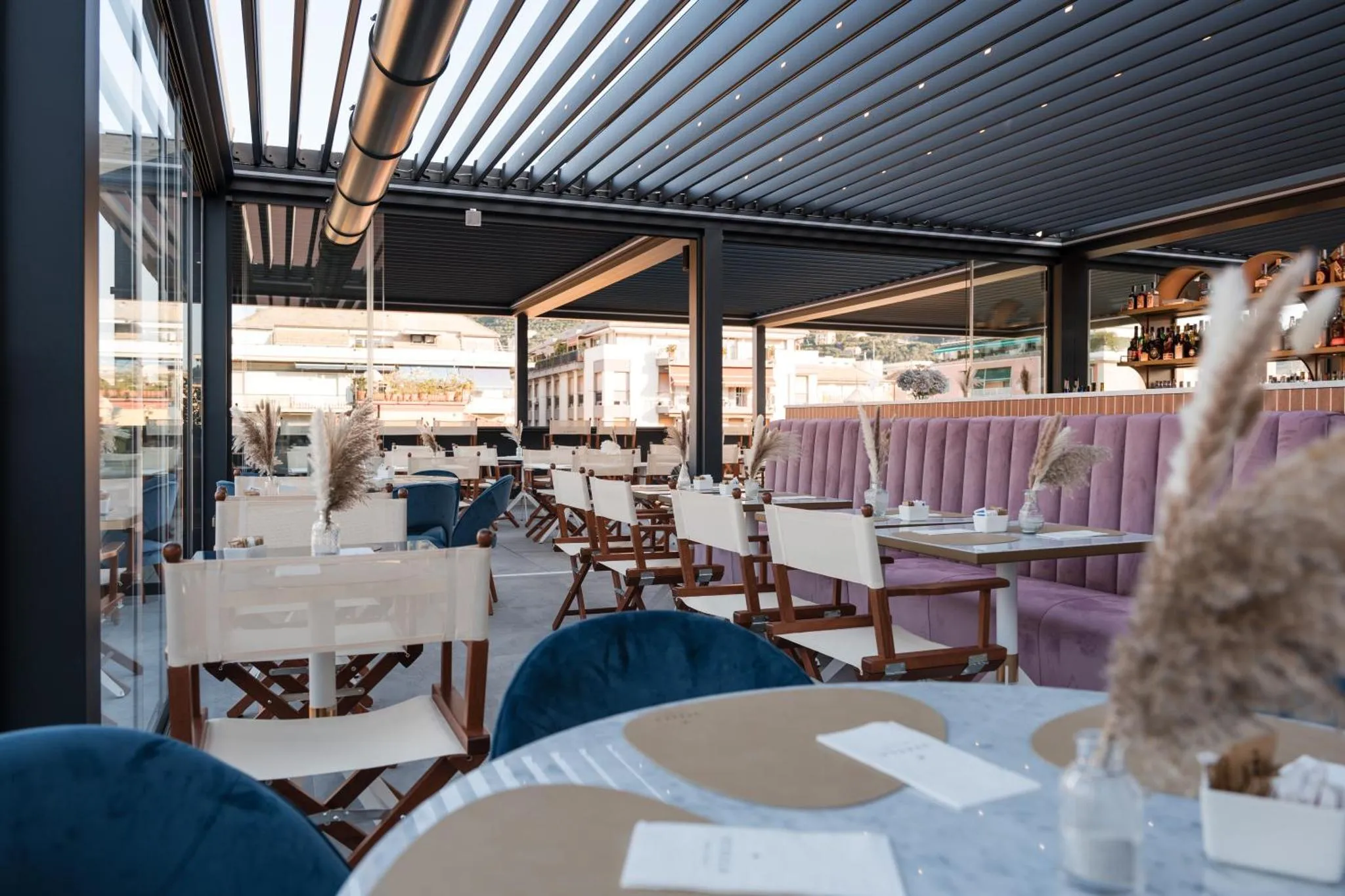 Une terrasse ombragée avec des tables et des chaises pour les repas.