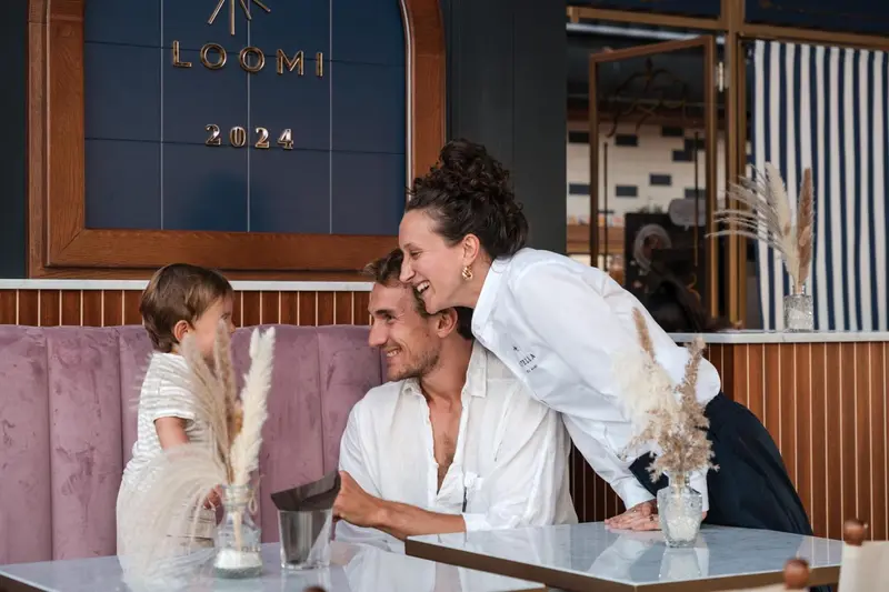 Une famille rit ensemble dans un intérieur chaleureux et décoré.
