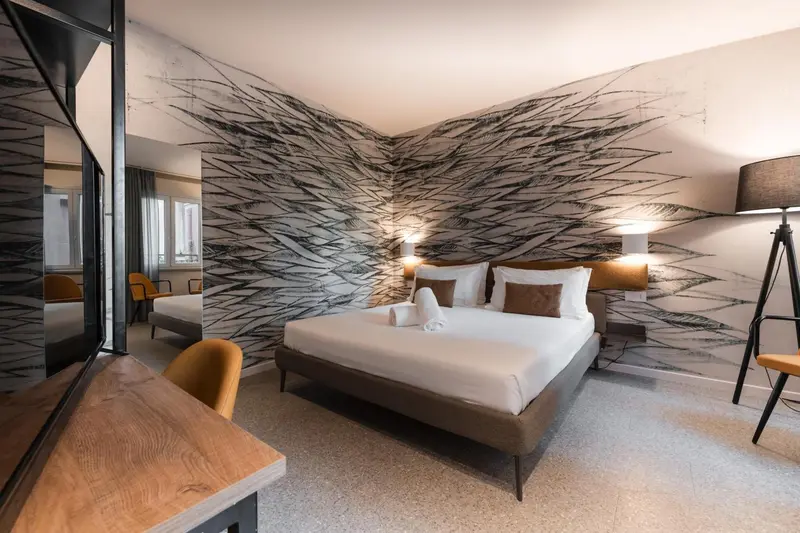 Une chambre moderne avec un grand lit et un mur décoratif.