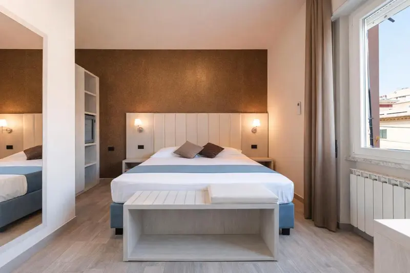 Chambre lumineuse avec un grand lit et une décoration moderne.