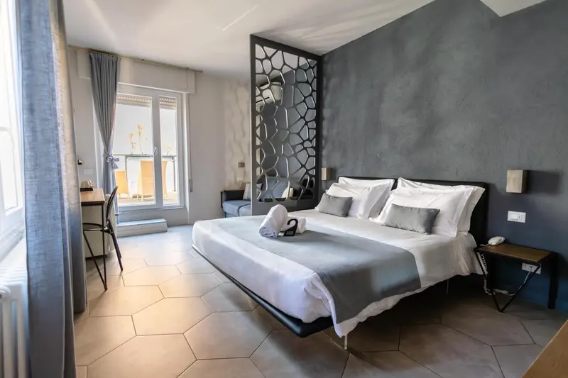Une chambre lumineuse avec un grand lit et un balcon.