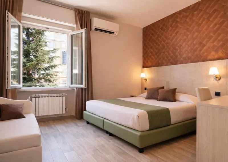 Une chambre lumineuse avec un lit double et une fenêtre ouverte.