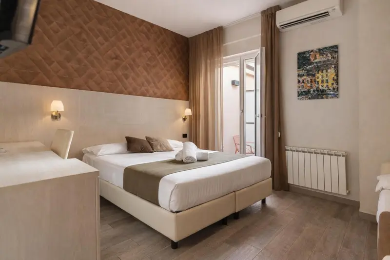 Une chambre lumineuse avec un lit double et un accès à un balcon.