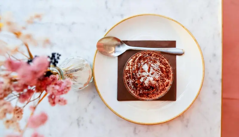 Assiette de dessert au chocolat avec une cuillère et une fleur.