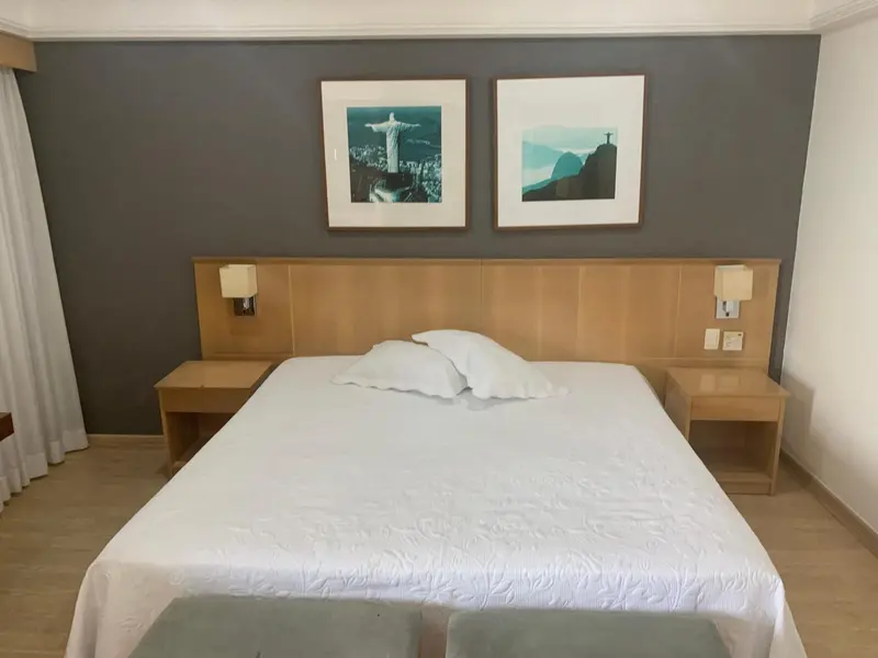 Une chambre lumineuse avec un grand lit recouvert d'une courtepointe blanche.