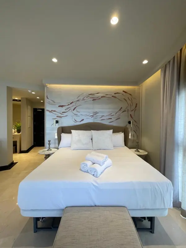 Une chambre lumineuse avec un grand lit recouvert de draps blancs.