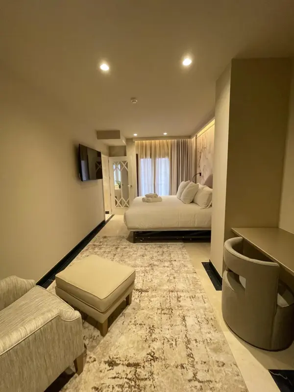 Une chambre d'hôtel lumineuse avec un grand lit et un coin salon.