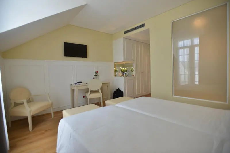 Une chambre lumineuse avec un lit et un coin bureau.