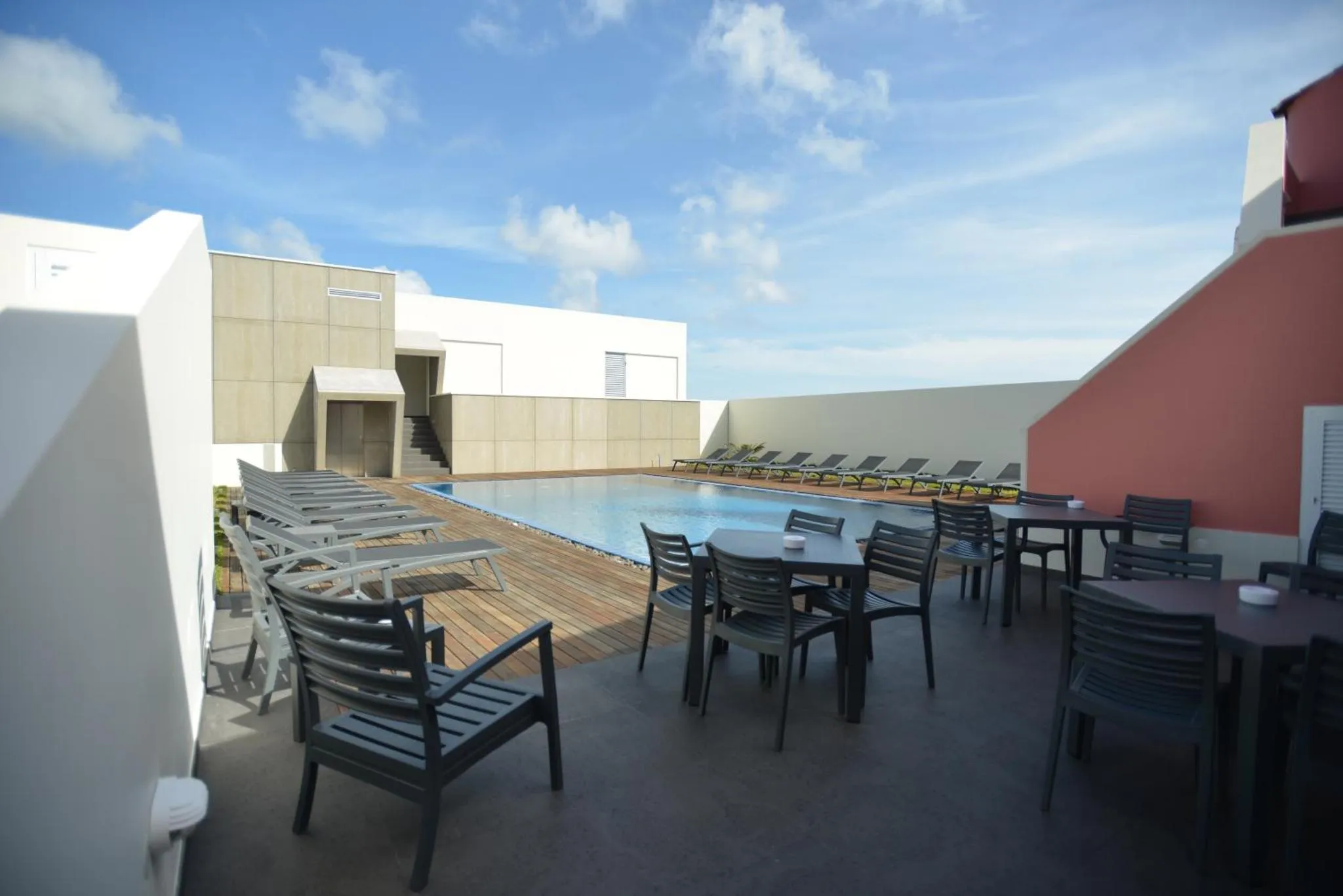 Terrasse avec piscine et mobilier de détente.