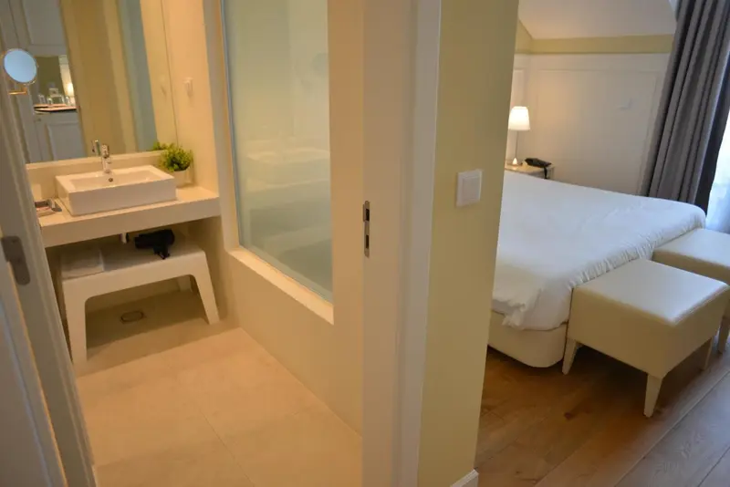 Une salle de bain moderne s'ouvre sur une chambre lumineuse.