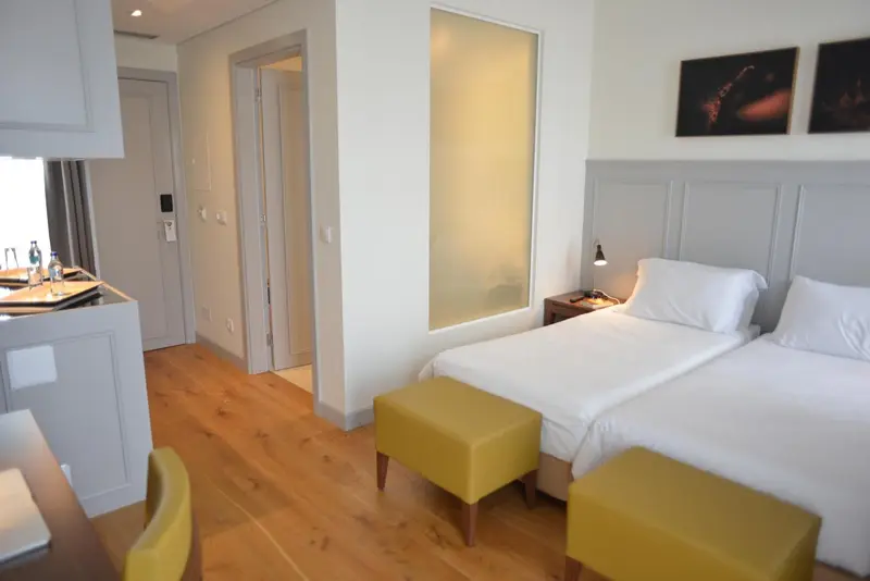 Une chambre lumineuse avec un lit et un coin cuisine.