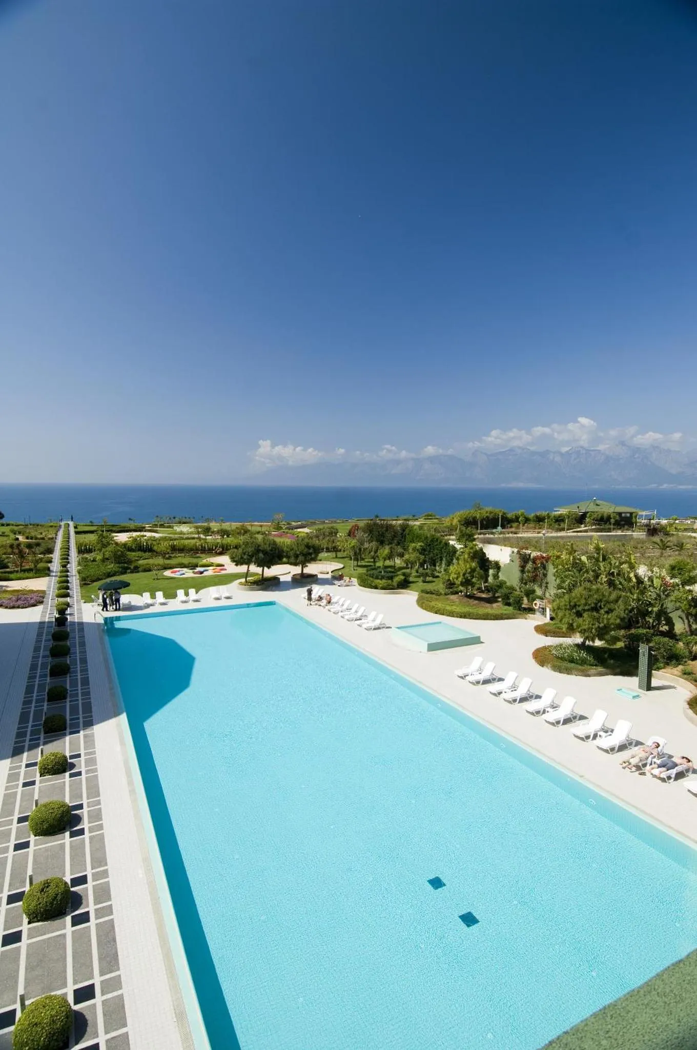 Une piscine à débordement offre une vue sur la mer et les collines environnantes.