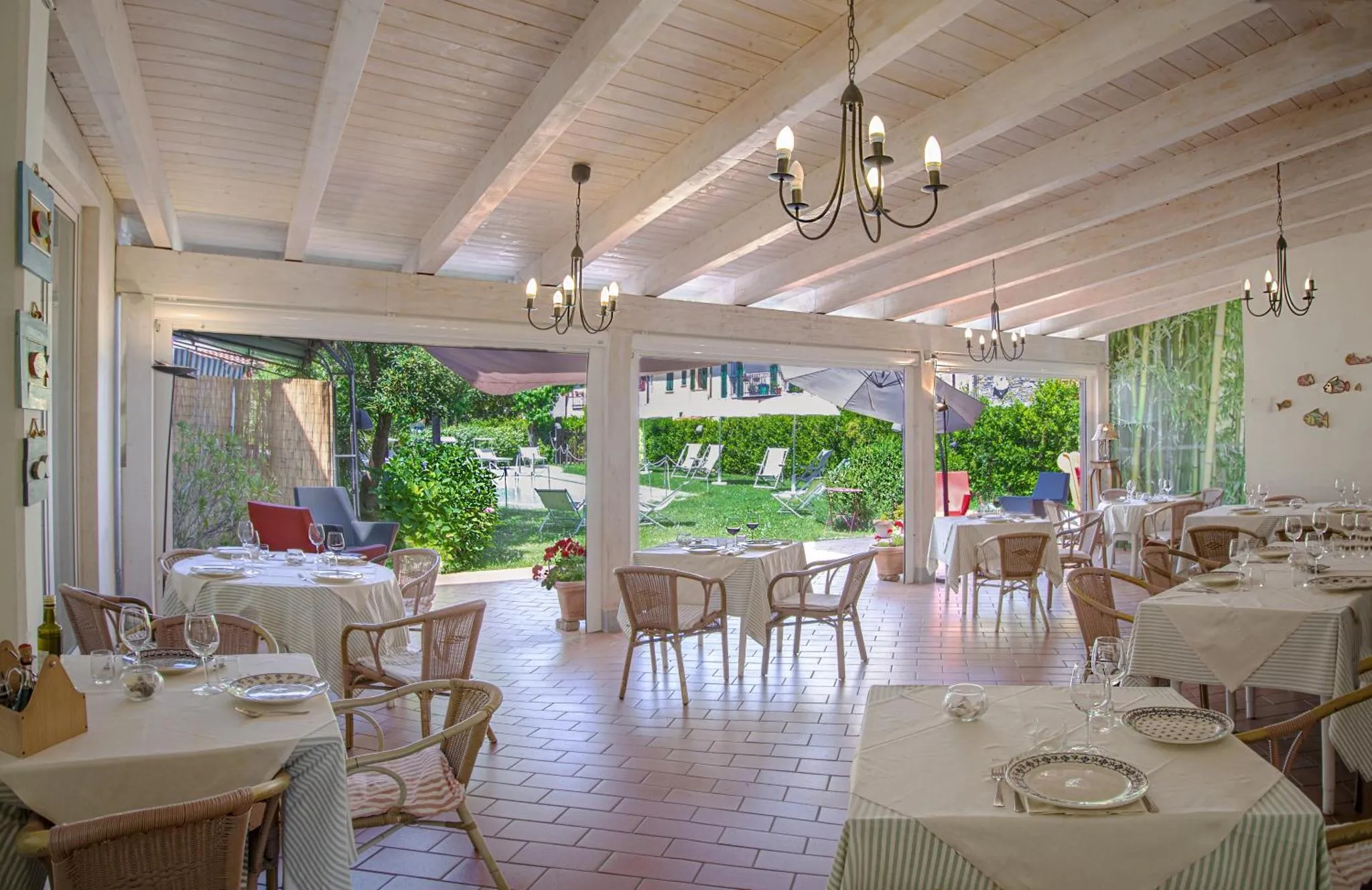 Une salle à manger lumineuse avec des tables dressées et une vue sur un jardin.