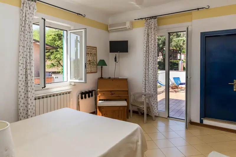 Une chambre lumineuse avec un piano et un accès à une terrasse.