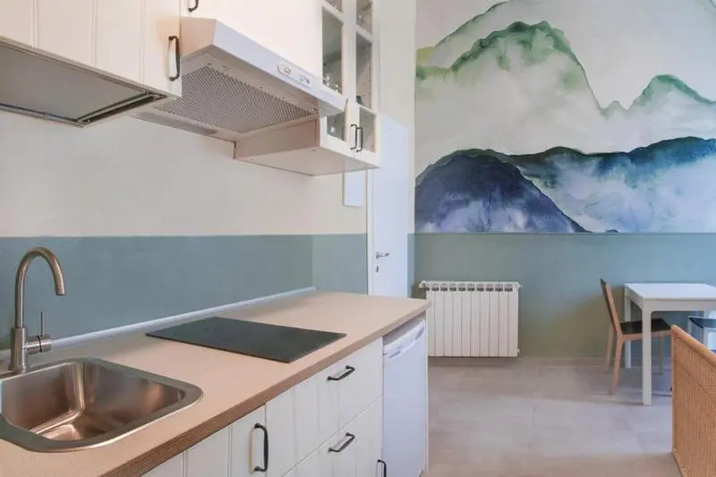 Une cuisine moderne avec un évier en inox et un plan de travail clair.