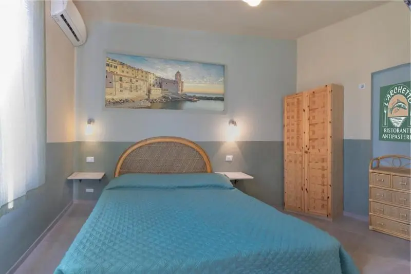 Une chambre lumineuse avec un lit double et un tableau mural.