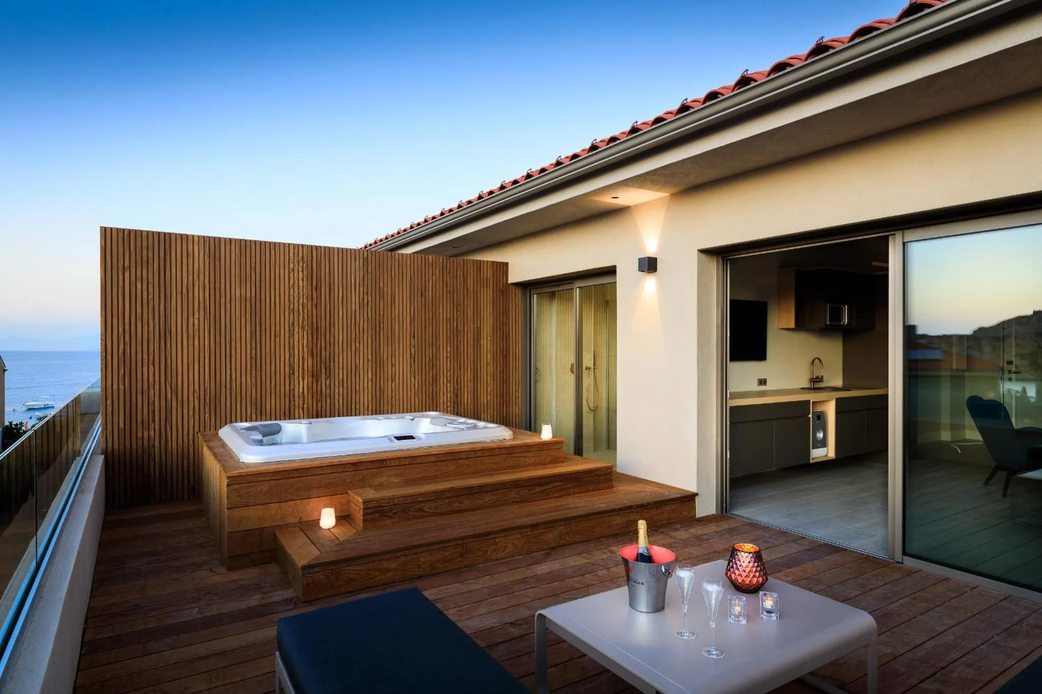 Terrasse avec jacuzzi et vue sur la mer au crépuscule.