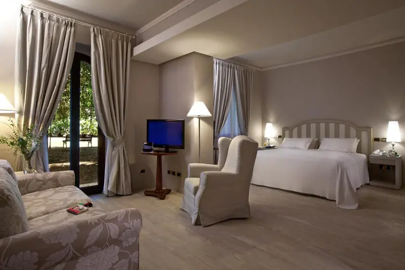 Une chambre lumineuse avec un lit et un coin salon.