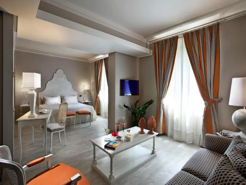 Une chambre lumineuse avec un lit à baldaquin et un coin salon.