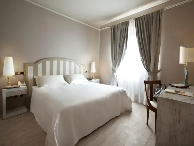 Une chambre lumineuse avec un grand lit et un bureau.