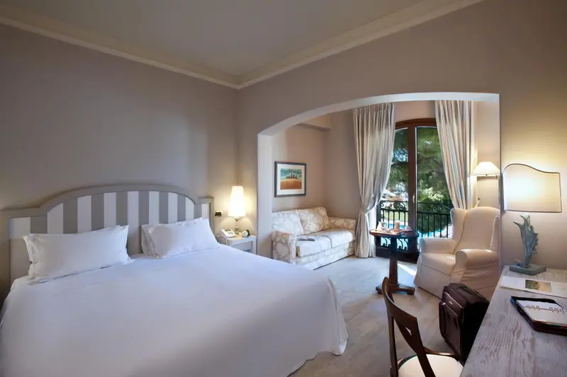 Une chambre lumineuse avec un grand lit et un coin salon.