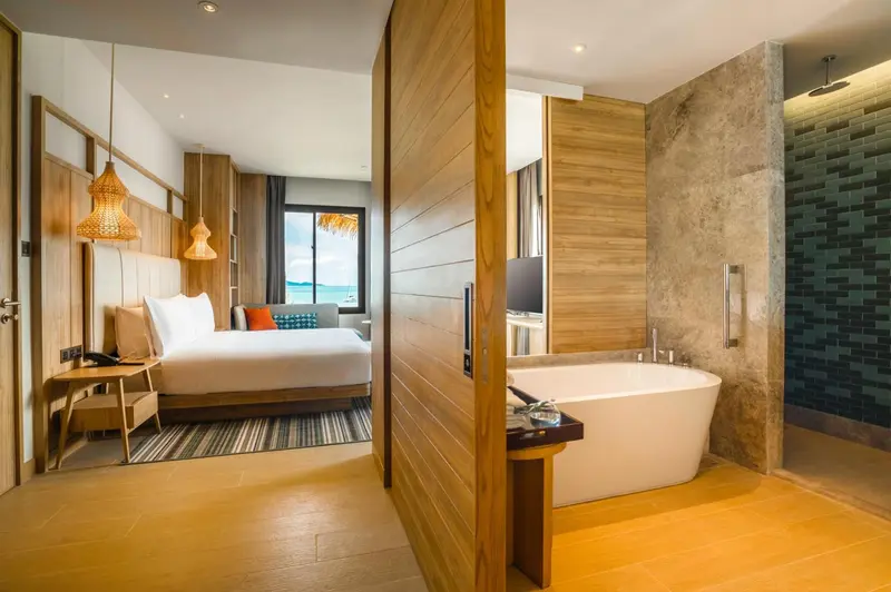 Chambre lumineuse avec un lit confortable et une baignoire moderne.