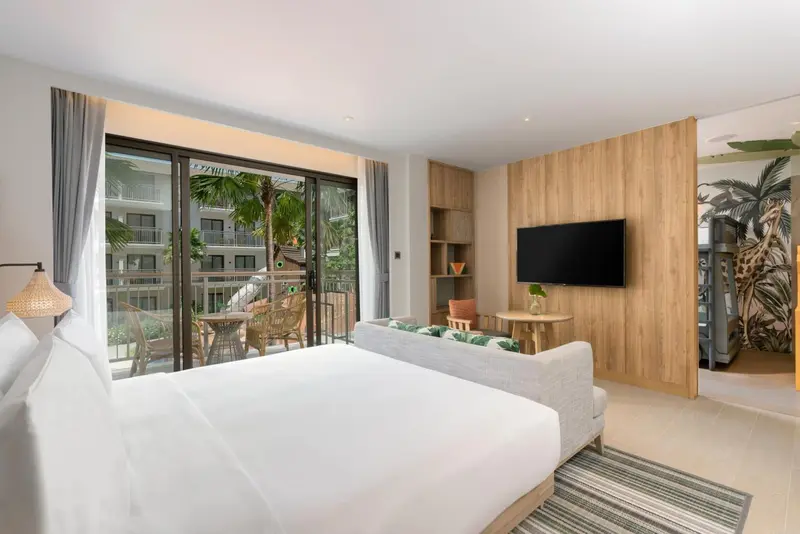 Une chambre lumineuse avec un grand lit et un accès à un balcon.