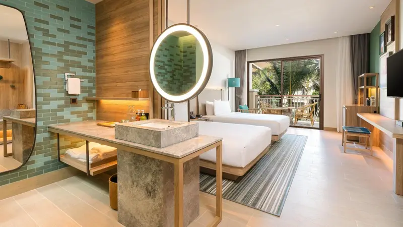 Une chambre lumineuse avec un grand lit et un espace lavabo moderne.