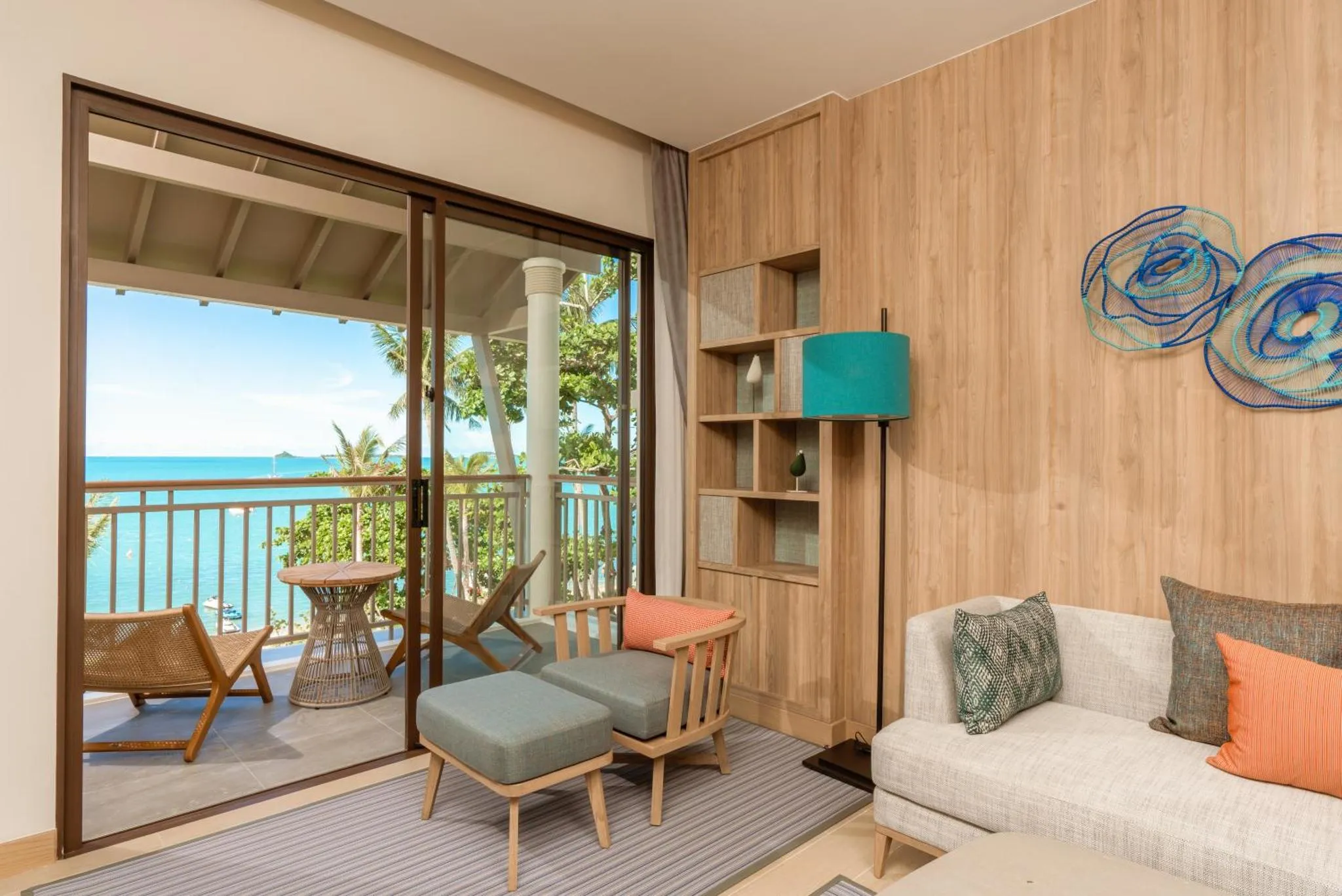 Espace de détente lumineux avec accès à une terrasse offrant une vue sur la mer.