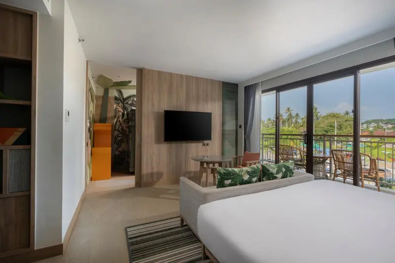 Espace de vie lumineux avec canapé et vue sur la végétation.