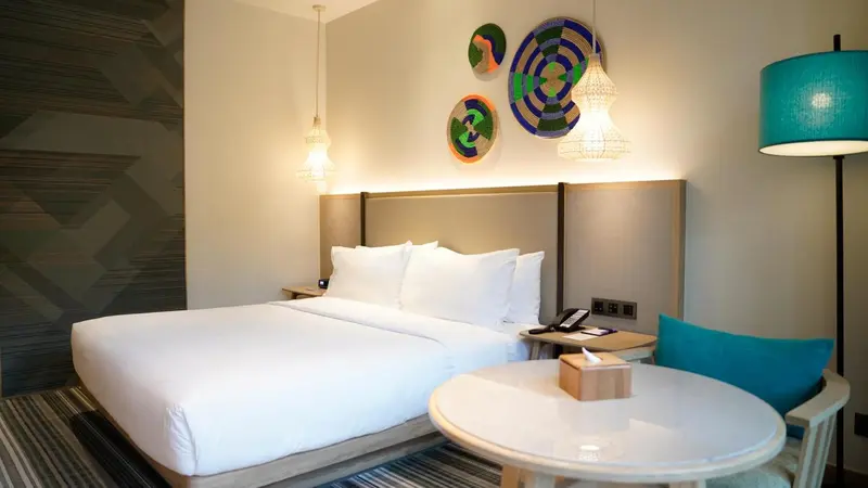 Une chambre lumineuse avec un grand lit et une table ronde.