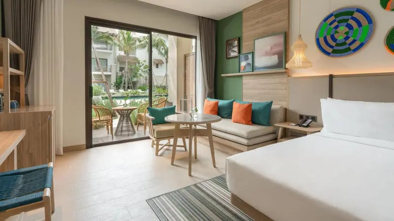 Espace de vie lumineux avec canapé, table basse et accès à une terrasse.